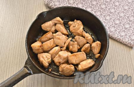 В сковороду вливаем растительное масло, даём ему немного прогреться, а затем выкладываем замаринованные кусочки курицы. Периодически перемешивая, обжариваем кусочки куриного мяса на среднем огне до лёгкой румяной корочки (примерно 5-7 минут).