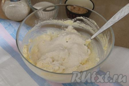 В получившуюся массу всыпать разрыхлитель и соль, начать частями добавлять просеянную муку, перемешивая творожное тесто сначала ложкой.