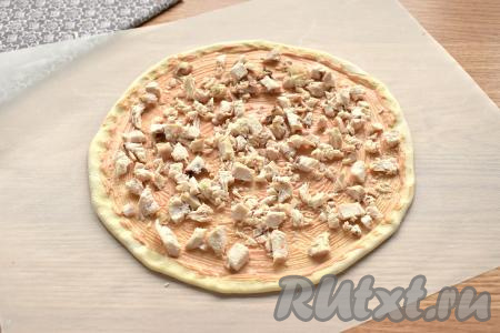 Остывшее отварное куриное филе нарезаем на кусочки и раскладываем по основанию пиццы.
