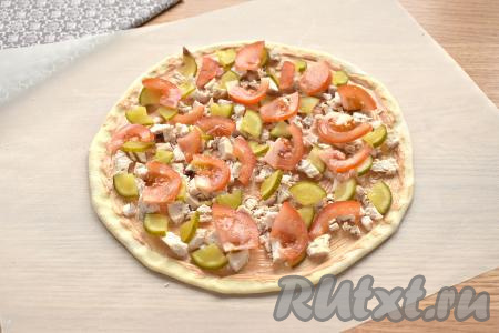 Нарезаем помидор на тонкие дольки и распределяем по пицце.