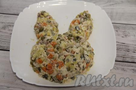 ​​​​​​Выложить салат на плоскую тарелку и сформировать мордочку в виде кролика (зайчика).