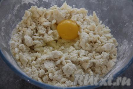 Перетереть содержимое миски руками до получения крошки. В получившуюся крошку добавить сырое яйцо.