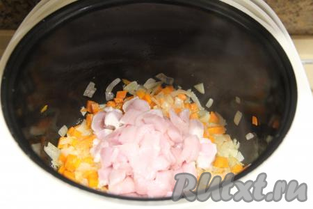 К обжаренным овощам в чашу мультиварки добавить куриное мясо, нарезанное на средние кубики (я обычно нарезаю на кубики с размером стороны 1,5-2 сантиметра), перемешать.
