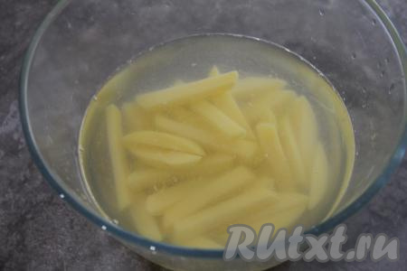 Картошку почистить, нарезать на брусочки и замочить в ледяной воде на 10 минут. Холодная вода удалит крахмал из картошки и она не будет приставать к чаше мультиварки во время жарки во фритюре.