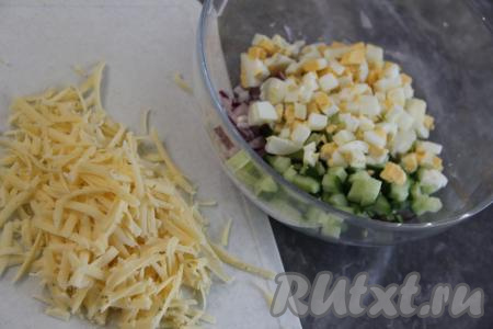 Твёрдый сыр натереть на тёрке. Вместо твёрдого сыра можно взять плавленный сырок. Соединить сыр, огурец, яйца и лук в глубоком салатнике.