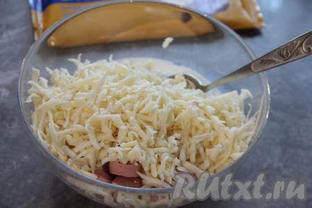 Сыр натереть на тёрке и добавить в миску к яйцам, молоку и сосискам, перемешать массу.