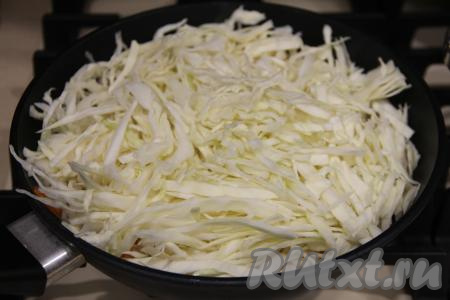 Нарезать капусту достаточно тонко и добавить в сковороду с курицей и овощами, хорошо перемешать.