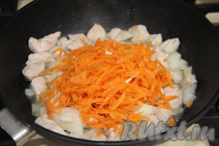 Лук обжаривать с куриным мясом минуты 3, иногда помешивая. Затем выложить очищенную морковку, натёртую на крупной тёрке, перемешать, обжаривать мясо с овощами 3-4 минуты, не забывая периодически помешивать.