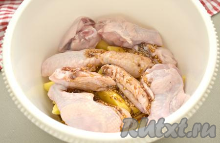 Получившуюся смесь соевого соуса, масла и специй переливаем к картошке и куриным крылышкам, хорошо перемешиваем.