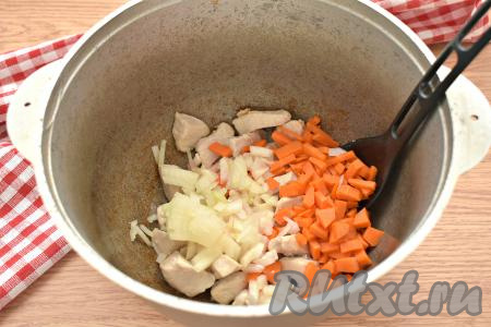 Морковь и лук очищаем. К обжаренным кусочкам курицы добавляем лук, нарезанный на кусочки, и морковку, нарезанную на кубики (или брусочки), перемешиваем и обжариваем минут 5-7, немного убавив огонь и иногда помешивая.