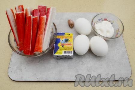 Подготовить продукты для приготовления закуски "Рафаэлло" из крабовых палочек и сыра. Заранее сварить куриные яйца вкрутую (варить после закипания воды минут 9-10), остудить их и очистить. Слегка разморозить крабовые палочки при комнатной температуре. Крабовые палочки нужно будет в дальнейшем натирать на тёрке, слегка подмороженные палочки натирать немного проще. Хотя и полностью размороженные крабовые палочки натираются достаточно легко. Я обычно эту закуску делаю с плавленным сырком, но можно готовить и с твёрдым сыром.