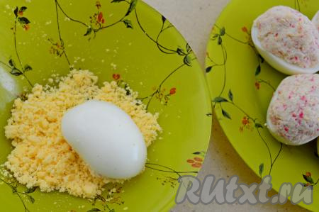 Затем каждое фаршированное яйцо окунаем в отложенную крошку из желтков так, чтобы начинка получилась присыпанной желтками.