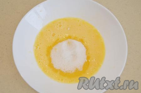 Сперва приготовим кляр, для этого в глубокую миску нужно разбить сырое яйцо, размешать его венчиком до однородности, после этого всыпать сахар и соль.