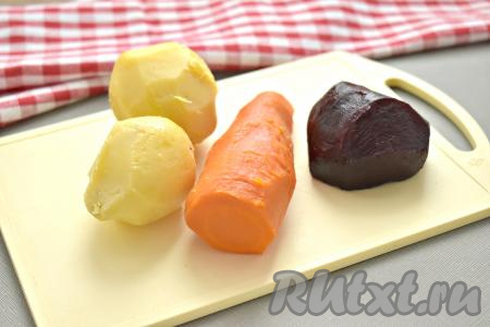 Промываем под проточной водой картошку, свеклу и морковь, очищать корнеплоды не нужно. Картошку отвариваем с момента закипания воды в течение 20 минут, морковку - 25-30 минут, свеклу – 40-45 минут (я отвариваю свеклу отдельно, чтобы она в процессе варки не окрасила картошку с морковью). Готовые овощи будут легко прокалываться ножом. Варёные овощи ставим под холодную воду, остужаем, а затем очищаем и сразу начинаем готовить винегрет. Очищаем половину луковицы.