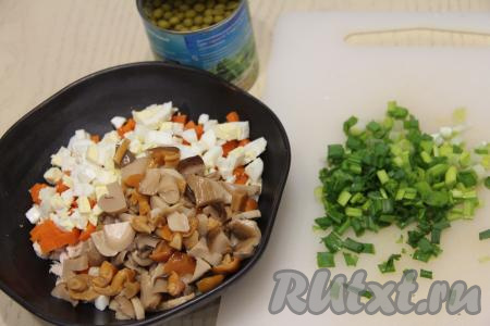  С грибочков слить маринад, если грибы крупные, тогда их нужно нарезать на небольшие кусочки. Соединить в салатнике куриное мясо, яйца, маринованные грибы, морковь и мелко нарезанный зелёный лук.