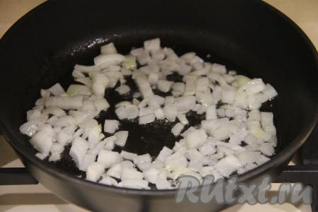 Луковицу почистить и мелко нарезать. Влить растительное масло в сковороду, выложить лук и обжаривать его на среднем огне, помешивая, до прозрачности (минуты 3-4).