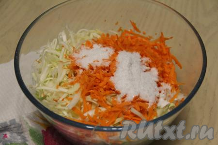 К моркови с капустой всыпать соль и сахар. Хорошо помять овощи руками, чтобы капуста дала сок.