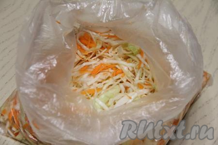 Переложить капусту с морковкой в целлофановый пакет. Завязать пакет и оставить его на сутки на кухонном столе. Периодически нужно встряхивать капусту, чтобы ингредиенты хорошо перемешивались между собой.