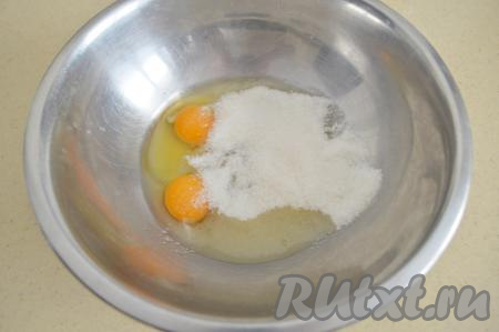 Вбить два сырых яйца в достаточно объёмную миску, всыпать сахар.