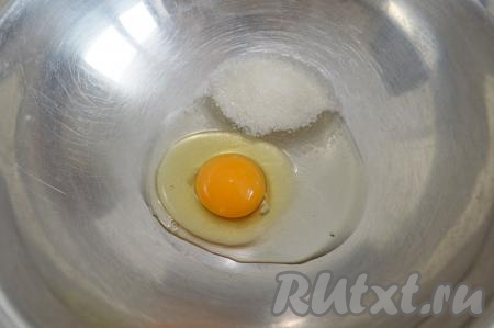 В глубокую миску вбить сырое яйцо и всыпать сахар.