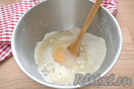 К муке всыпаем 1 чайную ложку без верха соли, добавляем яйцо и вливаем 150 миллилитров тёплой кипячёной воды, перемешиваем тесто вначале лопаткой (или столовой ложкой).