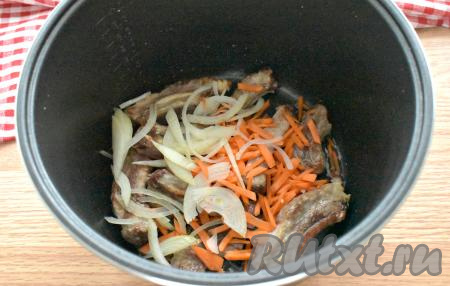 Через 15 минут к рёбрышкам добавляем морковь, нарезанную на тонкие брусочки, и лук, нарезанный полукольцами, обжариваем овощи с мясом, периодически перемешивая, до окончания программы "Жарка".