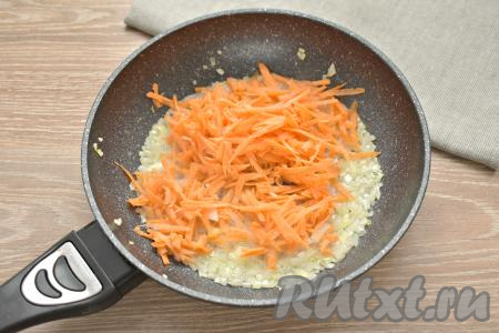 После того как лук станет мягким, выкладываем к нему натёртую морковку, перемешиваем и обжариваем овощи 3-4 минуты, иногда их помешивая.