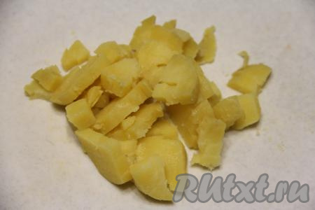 Картошку почистить и нарезать на средние кубики. Для "Оливье" старайтесь нарезать все ингредиенты на примерно одинаковые кубики, размер которых должен быть примерно равен размеру горошка, тогда салат получится особенно аппетитным.