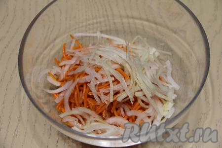 Лук почистить и нарезать на тонкие полукольца. Соединить в миске корейскую морковку и лук, перемешать.