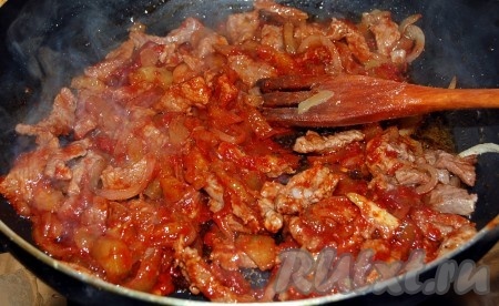 Добавить к мясу с луком соленые огурцы и томатную пасту, перемешать и тушить 30 минут.