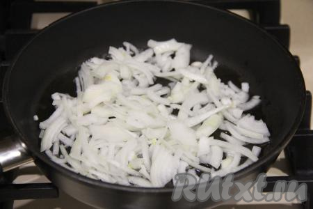 Почистить лук, нарезать его на тонкие полукольца, выложить в сковороду с растительным маслом. Обжарить лук до прозрачности (в течение 3-4 минут), иногда помешивая, на среднем огне.