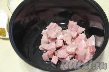 Растительное масло влить в чашу мультиварки, затем выставить режим "Жарка". Выложить кусочки свинины, обжаривать мясо, не закрывая крышку мультиварки, минут 10, периодически перемешивая. 