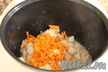 После того как свинина обжарится 10 минут, добавить к ней морковку с луком. Обжаривать мясо с овощами, не закрывая крышку мультиварки, минут 10, не забывая периодически перемешивать.