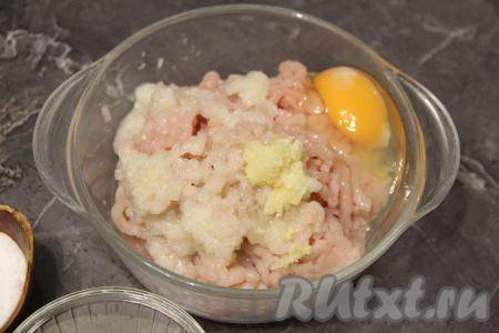 В миску с фаршем добавить лук, пропущенный через мясорубку, сырое яйцо и пропущенный через пресс чеснок.