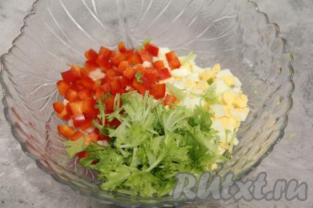 Сладкий перец вымыть, удалить семена, затем нарезать на небольшие кубики и выложить в салатник. Листья салата нарвать руками, переложить в салатник.