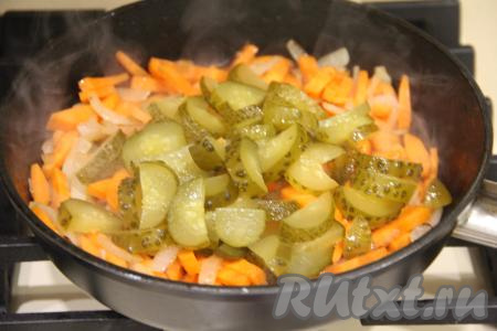 Обжарить овощи 5 минут, периодически перемешивая, затем добавить огурцы, нарезанные на полукружочки, перемешать.