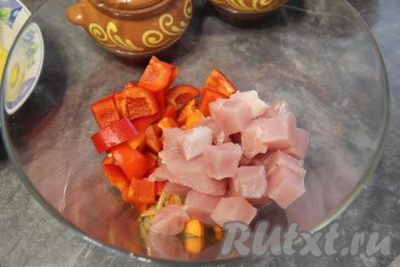 В миску с обжаренными овощами добавить болгарский перец, нарезанный на крупные квадратики, и кусочки индейки.