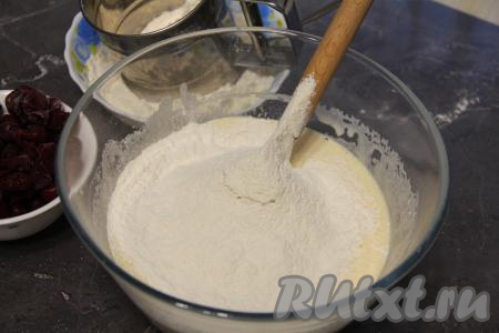В получившуюся смесь добавить разрыхлитель и соль, частями начать всыпать просеянную муку, перемешивая тесто для кекса лопаткой. 