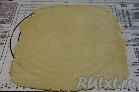 По прошествии часа раскатать тесто на присыпанной мукой поверхности (я раскатывала на силиконовом коврике) в тонкий пласт. 