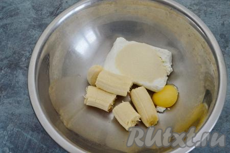 В подходящую миску положить творог, яичный желток, манную крупу и кусочки очищенного банана.