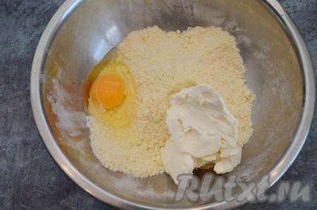 В миску с крошкой выложить творожный сыр и сырое яйцо.