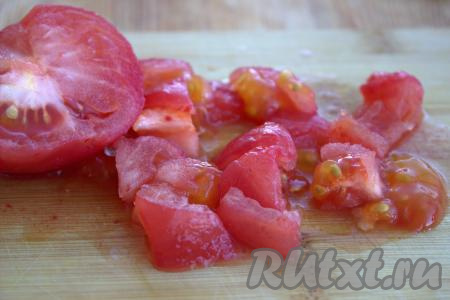 У помидора вырезать плодоножку. Очистить помидор от шкурки, для этого поместить помидор в глубокую посуду, залить полностью кипятком и оставить минуты на 2, затем залить холодной водой и снять шкурку. Нарезать помидор на средние кубики.
