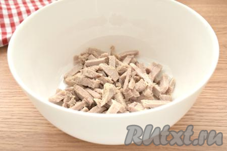 Варёную свинину нарезаем на небольшие брусочки, перекладываем в салатник.