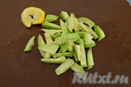 Авокадо разрезать пополам, удалить косточку и снять кожуру. Нарезать авокадо на кусочки. Затем сбрызнуть свежевыжатым лимонным соком. Сок нужен для того, чтобы авокадо не почернел.