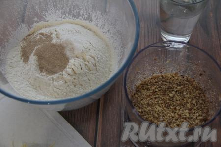 Муку просеять в достаточно глубокую миску, добавить соль, сахар и сухие дрожжи. При помощи измельчителя измельчить грецкие орехи в крошку.