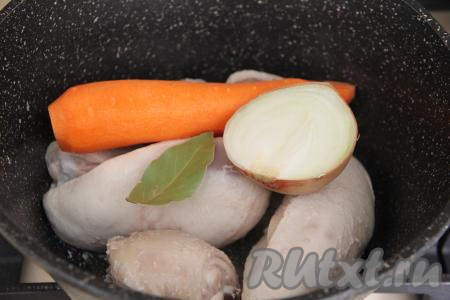 Лук промыть водой (я взяла половину крупной луковицы), очищать от шелухи его не нужно. Морковь очистить. В кастрюлю с кусочками куриного мяса добавить очищенную морковь, лавровый лист, лук в шелухе. 