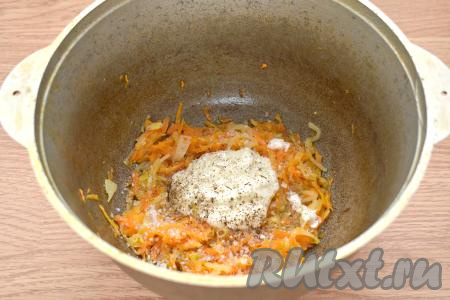 Добавляем к морковке и луку сметану, солим и перчим по вкусу, перемешиваем, тушим на небольшом огне 2-3 минуты.