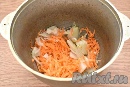 Пока кусочки утки обжариваются, очищаем лук и морковь. Нарезаем луковицу на полукольца. Натираем на крупной тёрке морковку. В казан наливаем 2 столовых ложки растительного масла, ставим на огонь. Когда масло разогреется, перекладываем в казан морковку с луком, обжариваем овощи на среднем огне 5-7 минут (до мягкости моркови), иногда перемешиваем.