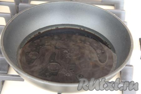 В сковороду с высокими бортиками влить 200 миллилитров горячей воды, добавить растительное масло и соевый соус.
