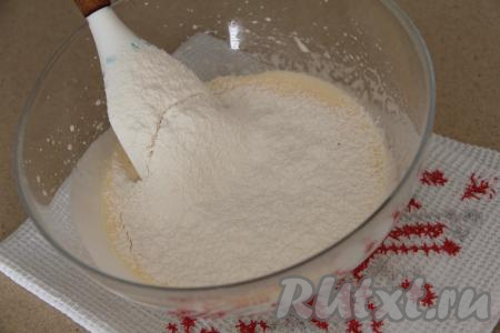 К яично-сахарной смеси влить растительное масло, перемешать лопаткой. Всыпать разрыхлитель и соль, начать частями добавлять просеянную муку, тщательно вмешивая её лопаткой в тесто. 
